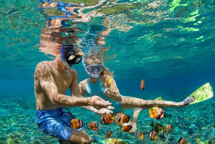 Young couple in snorkeling mask dive underwater in tropical sea near a DPA location