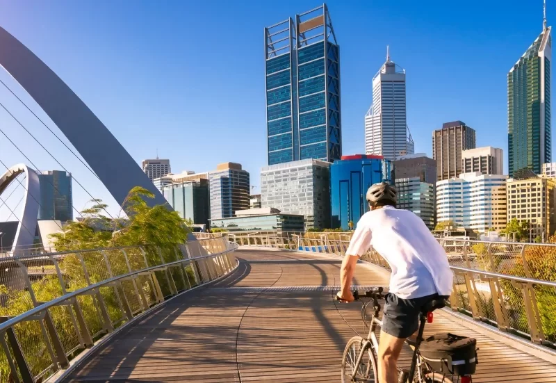 man riding a bike over a bridge and thinking about the GP Salary Survey from Alecto Australia.