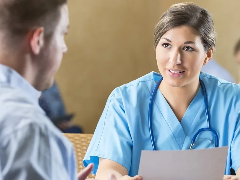 a female doctor interviewing a male, while looking at his Medical CV